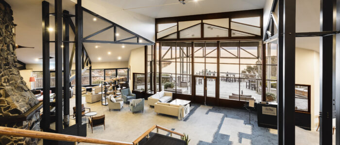 Interior of a contemporary lounge with a natural aesthetic, showcasing wooden features and spectacular views of Oyster Bay